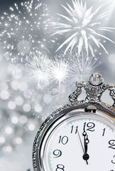 Obraz na płótnie Canvas Old clock with fireworks and holiday lights