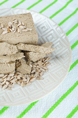 Sunflower halva on plate, on wooden background