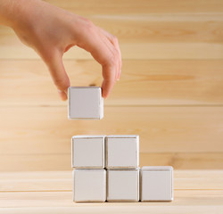 Educational cube in hand, on wooden background