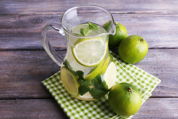 Lemonade in pitcher on wooden background