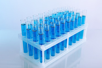 Blue water in a transparent test-tube on light background