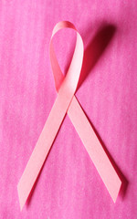 Pink breast cancer ribbon on pink background