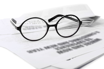 Glasses and newspapers, close-up