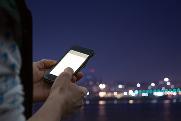 Typing messages  - with defocused city lights.