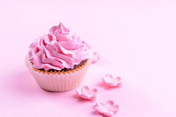 Delicious cupcake on pink background