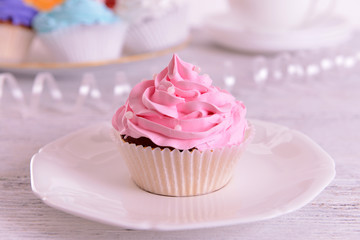Delicious cupcakes on plate on table close-up