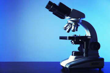 Microscope on table, on color background