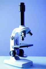 Microscope on table, on color background
