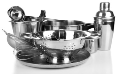 Stainless steel kitchenware on table, isolated on white