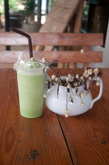 Milk Green tea smoothie in plastic cup on wood table