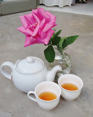 White kettle and two tea cups and roses