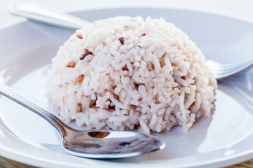 Rice with spoon and fork in white dish