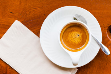 Cup of fresh espresso with spoon, napkin on table