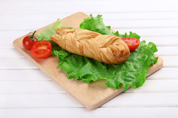 Smoked braided cheese on wooden table