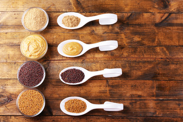 Mustard seeds, powder and sauce in spoons  and bowls
