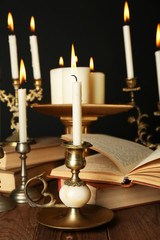Retro candlesticks with candles and books,