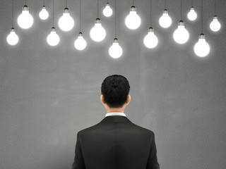 businessman with hanging lighting bulbs