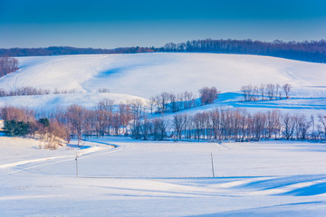 View of snow covered rolling hills and farm fields in rural York