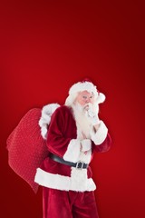 Composite image of santa asking for quiet with bag
