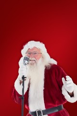 Composite image of santa claus is singing christmas songs