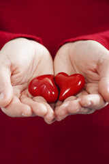 Fototapeta premium Red hearts in hands - St. Valentine concept