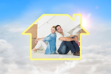 Composite image of smiling couple with boxes in a new house