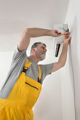 Electrical installation of air conditioner, electrician at work