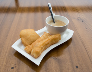 deep-fried doughstick and coffee on wood table,Thai breakfast
