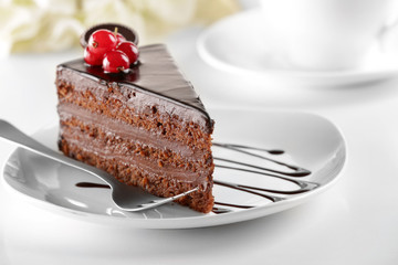 Delicious chocolate cake on plate on table on light background