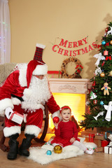 Santa Claus giving  present to  little cute girl near