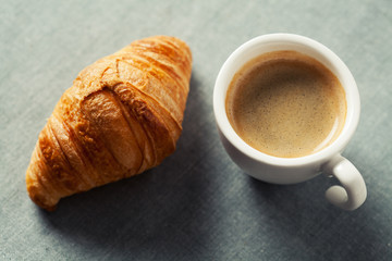 Breakfast concept: cup of coffee and croissant