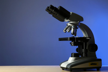 Microscope on table, on color background