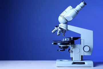 Microscope on table, on color background