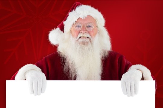 Composite image of santa looks over a sign