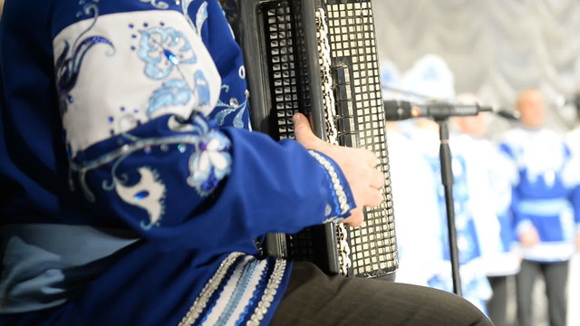 Accordionist in Russian national dress playing the concert
