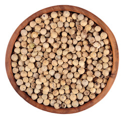 White pepper seeds in a wooden bowl on a white