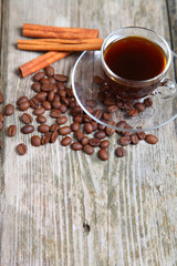 Transparent cup of coffee, beans and cinnamon sticks