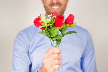 Young man giving a bouquet of roses