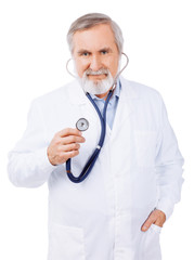 Mature doctor holding stethoscope