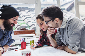 Teamwork. Three young architects working on a project