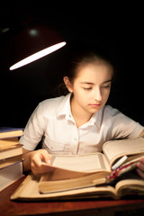 Young girl reading book at night dark at library