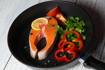 Fresh salmon steak in a pan grilled with vegetables