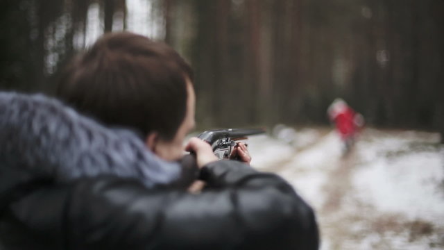 The man in the forest aiming a rifle in Santa Claus