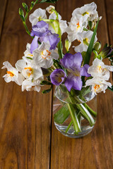 fresh garden flowers in glass on wooden table