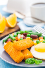 Fish sticks, fried egg and vegetables