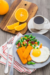Fish sticks, fried egg and vegetables