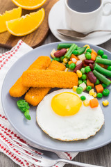 Fish sticks, fried egg and vegetables