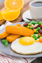 Fish sticks, fried egg and vegetables