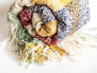 Warm fluffy plaid in a cage of various colors with a fringe