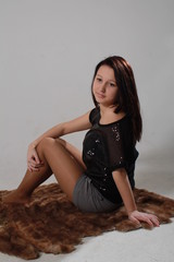 молодая девушка сидит в полоборота